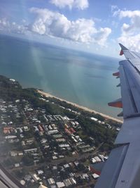 Aerial view of city by sea against sky