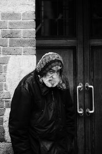 Midsection of man standing against door