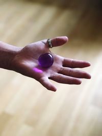 Cropped hand holding purple marble