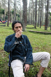 Portrait of young man sitting in park