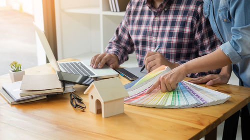 Rear view of woman working on table at home