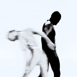 Side view of people dancing against white background