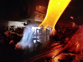 People on illuminated street at night