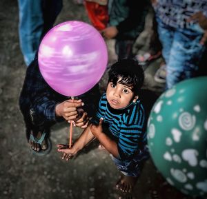 Full length of cute girl holding balloons