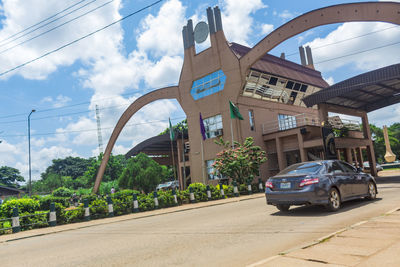 Cars on road against sky in city