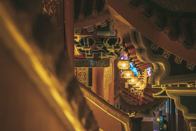 Illuminated lanterns hanging in temple outside building