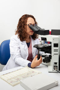 Cytologist looking at pap smear samples through a microscope. medical analysis concept.