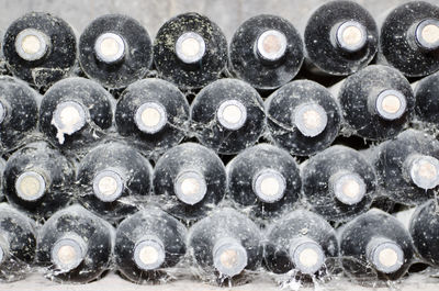 Heap of old wine bottles with dust and spider web
