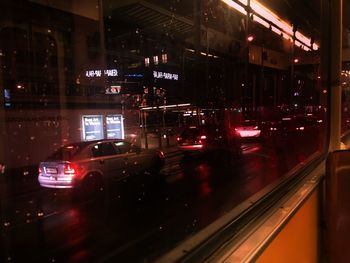 Cars on illuminated city street at night