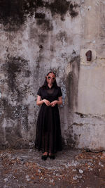 Portrait of woman standing against wall, halloween