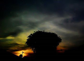 Low angle view of silhouette trees against cloudy sky