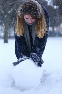 Young woman touching snowball