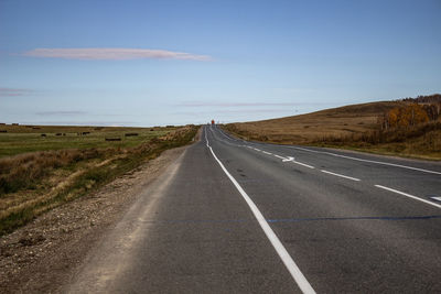 Empty road along countryside landscape