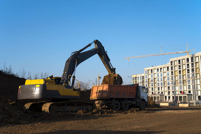 Construction site in city against clear sky