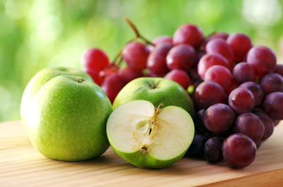 Close-up of granny smith apples and red grapes on table