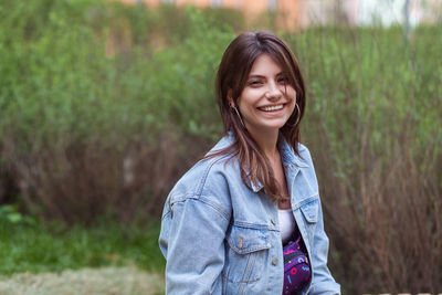 Portrait of young woman standing on field