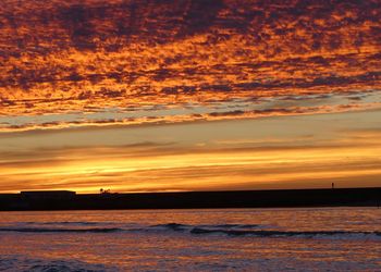 Scenic view of sea against orange sky