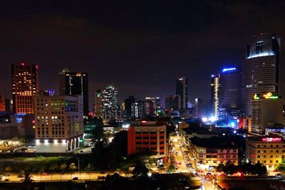 Illuminated buildings in city against sky at night