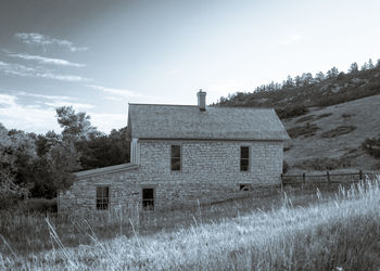 Abandoned building on field against sky