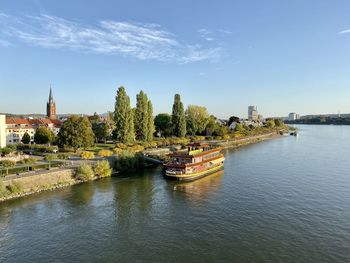 Scenic view of river by buildings against sky