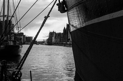 View of boats in river against cloudy sky