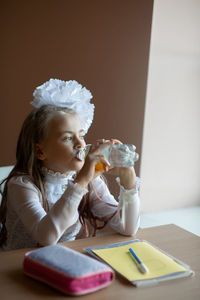 Portrait of cute girl holding table at home