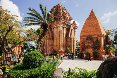 Group of people outside temple against building