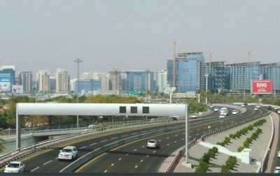 Vehicles on road in city against sky