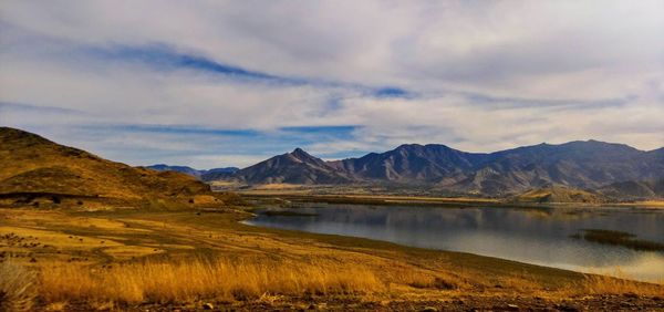 Scenic view of lake by mountains against sky