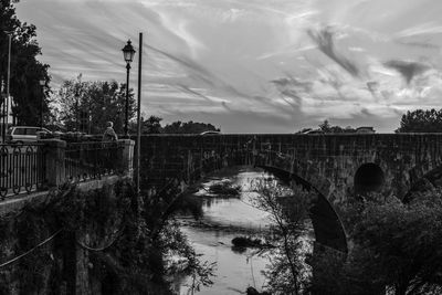 Arch bridge over river against sky