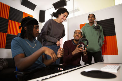 Portrait of rappers and sound engineers in recording studio