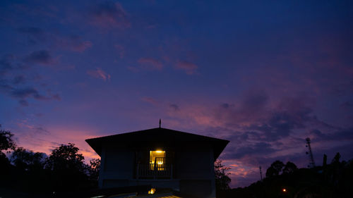 Low angle view of illuminated building against sky at sunset