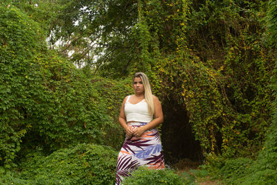 Young woman in hat amidst trees in forest