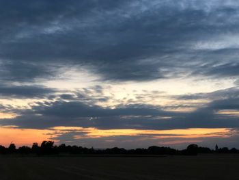 Scenic view of silhouette field against sky during sunset