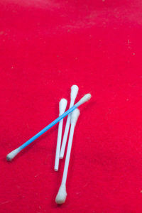 High angle view of colored pencils on red background