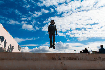 Rear view of woman standing against sky