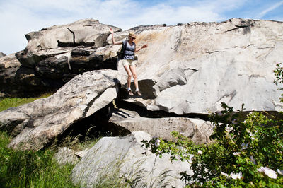 Low angle view of man on rock against sky