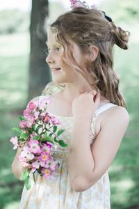 Close-up of smiling young woman standing against blurred background
