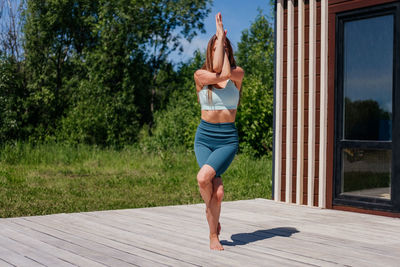 Full length of young woman exercising in park