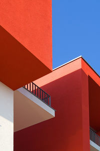 Low angle view of red buildings against clear blue sky