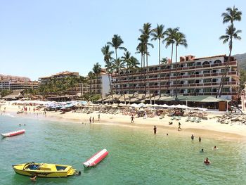 People on beach against clear sky