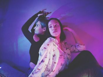 Portrait of young woman with arms raised