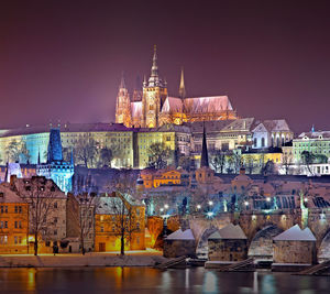 Illuminated buildings in city against sky