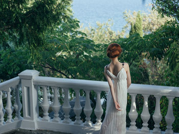 Rear view of woman standing on balcony