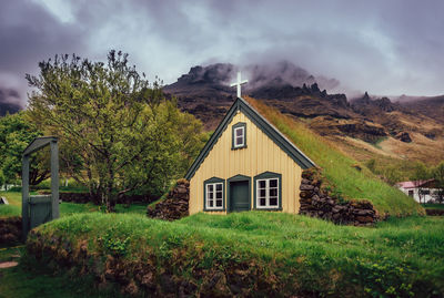 House amidst trees and buildings against sky