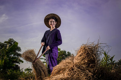 Farmer harvesting against sky at dusk