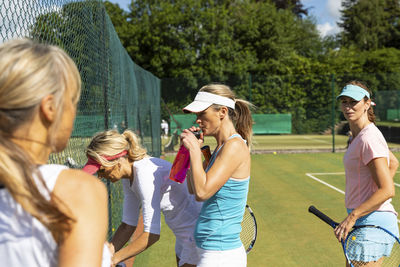 Mature women at tennis club taking a break from playing