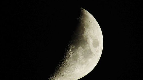 Low angle view of half moon against sky at night