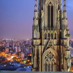 Cathedral of la plata against illuminated cityscape at night