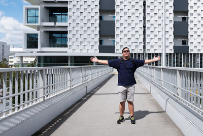 Full length portrait of smiling man in city